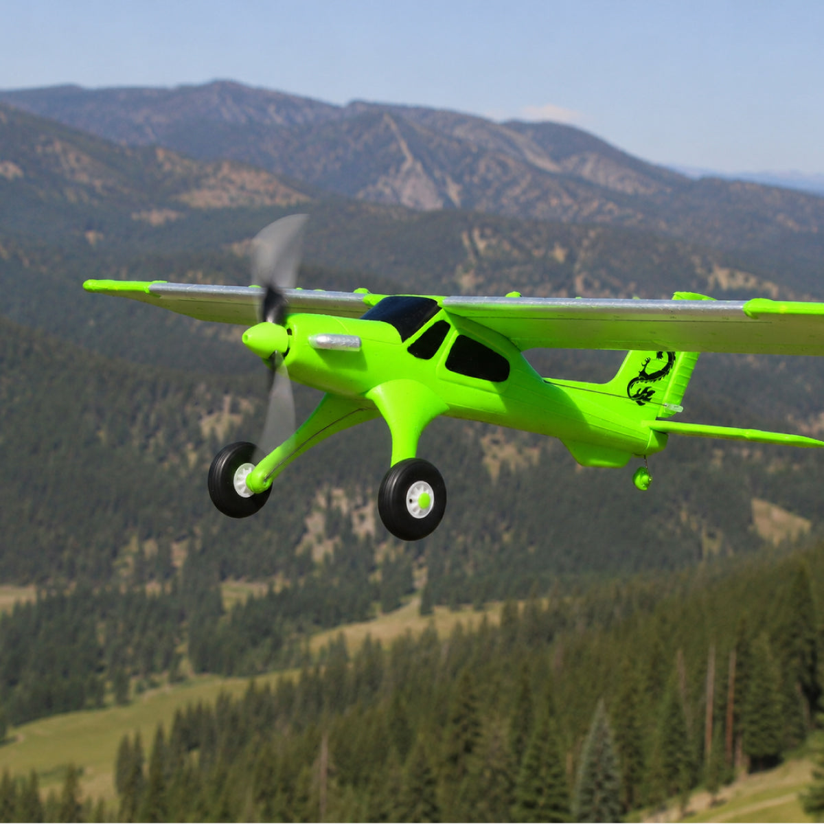 MF-X7 grünes RC Plane fliegt über bewaldete Berglandschaft